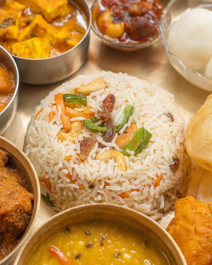 About Colorful Indian thali with rice, curry, and sides, offering a taste of traditional cuisine.