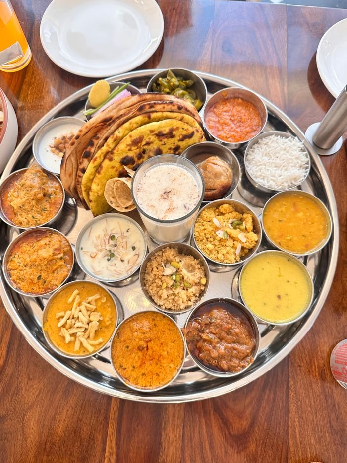Services A vibrant Indian thali with various dishes including chapati, curry, and rice, beautifully arranged on a tray.